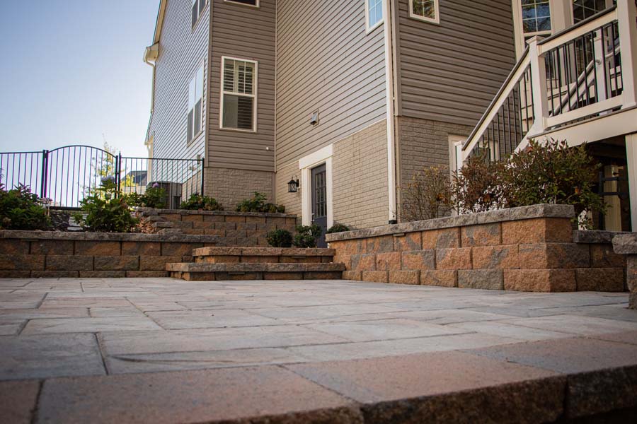 Stone patio with stairs and retention wall in background