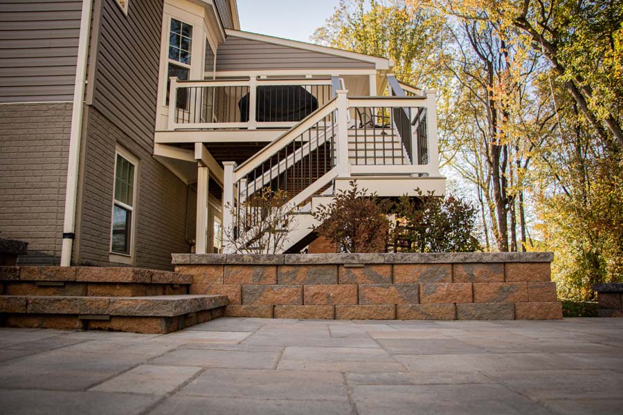 Stone patio, retention wall, and stairs to deck