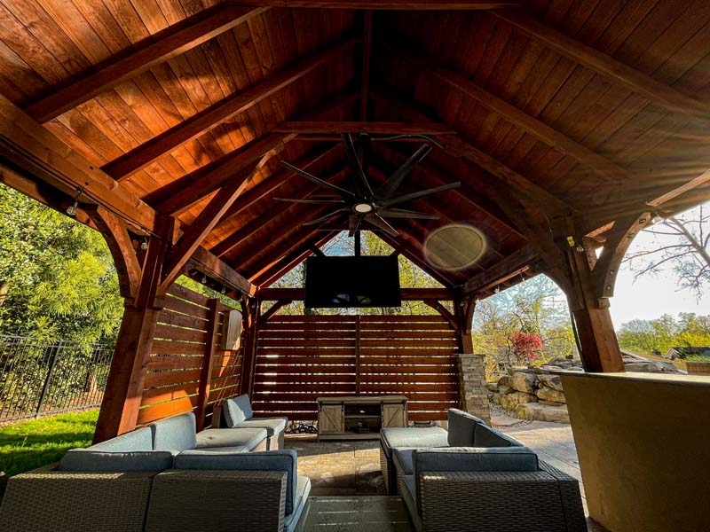 Wood covered patio with TV and furniture