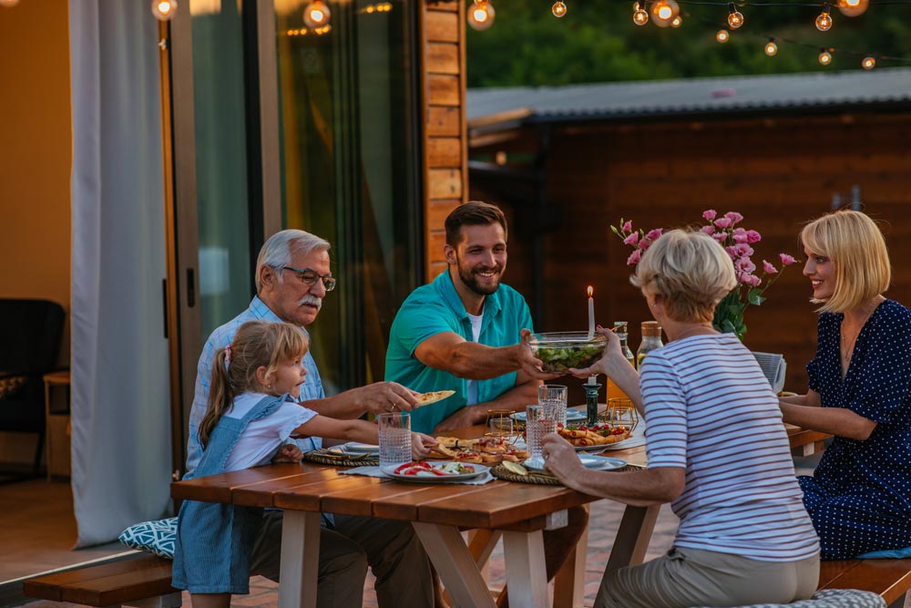 Backyard dinner party with string lights and shared dishes.