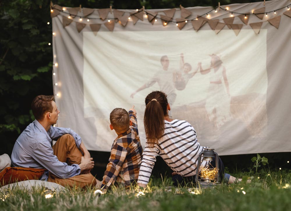 Cozy outdoor theater setup with string lights and seating.