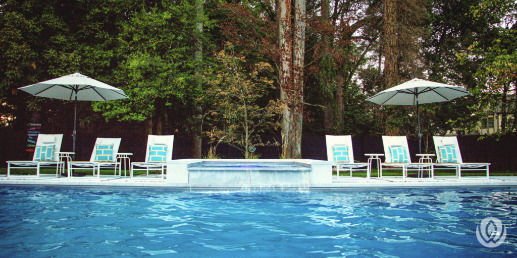 Backyard swimming pool with lounge chairs and umbrellas